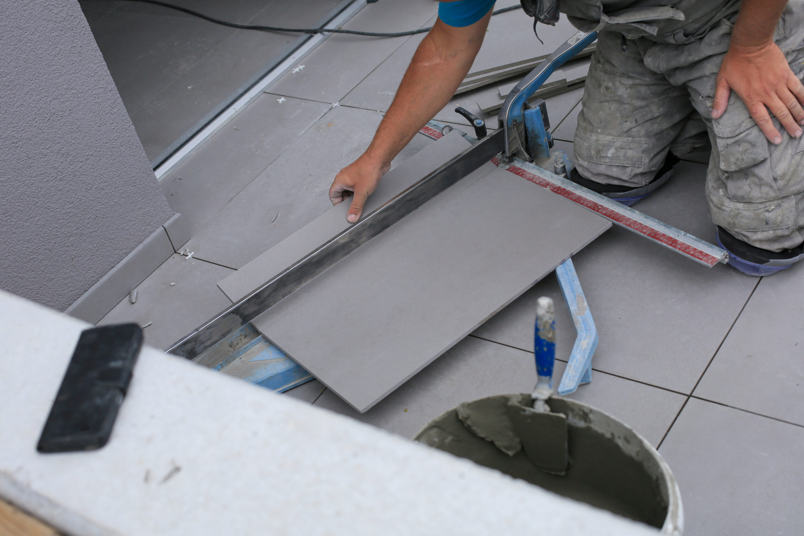 Tiler hands working on a new house entrance, local and professional handyman applying tiles to the steps.