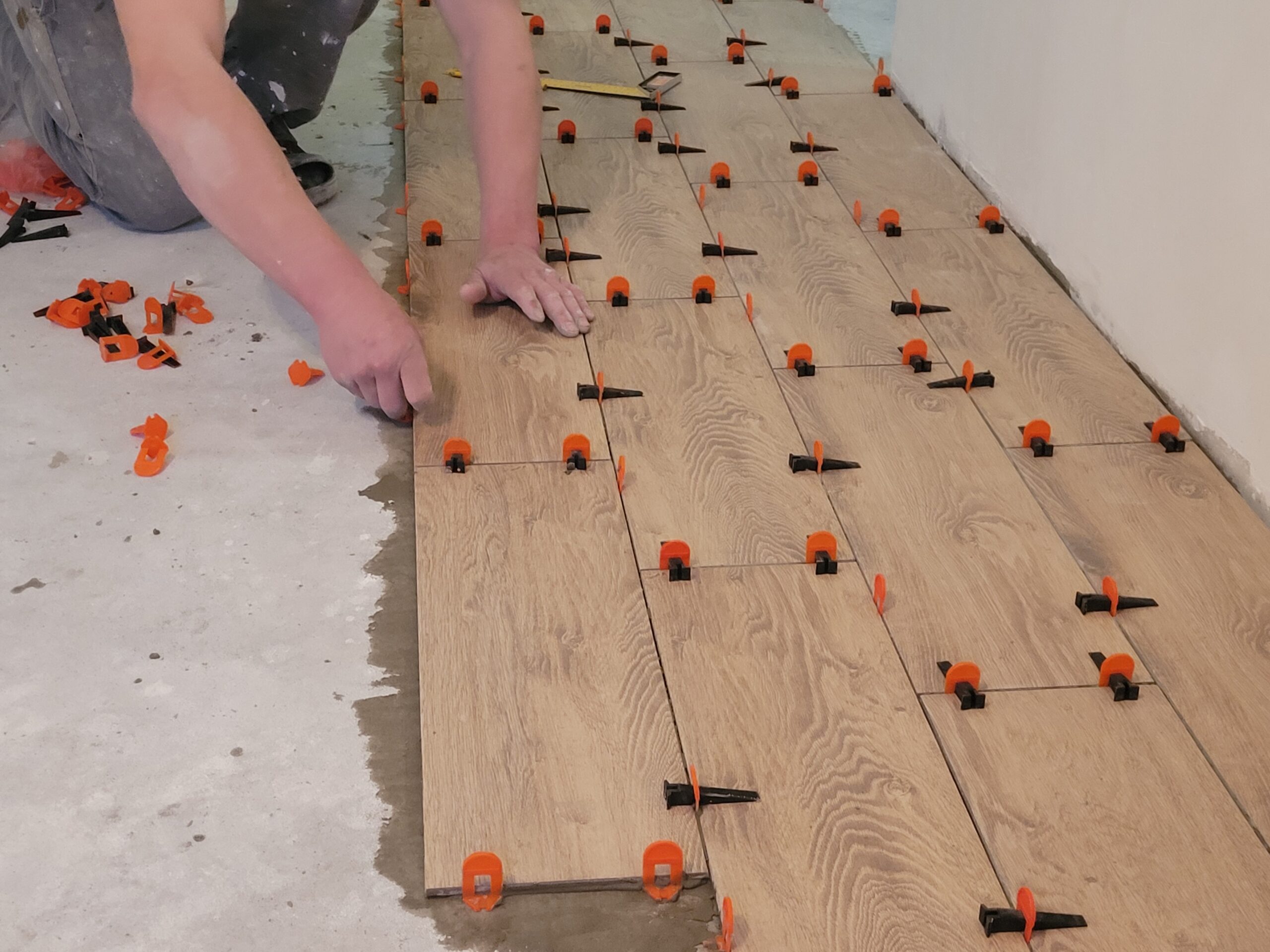 Laying tiles at home. Construction worker laid floor tiles.